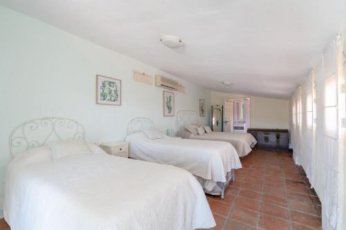 孔佩塔Finca Colica的配有白色床单的客房内的两张床