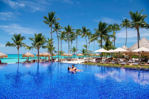鲁阿环礁Emerald Maldives Resort & Spa-Deluxe All Inclusive的坐在度假村游泳池里的男人