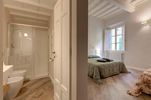 佛罗伦萨Lambert Apartment的一间卧室配有一张床,浴室设有淋浴。