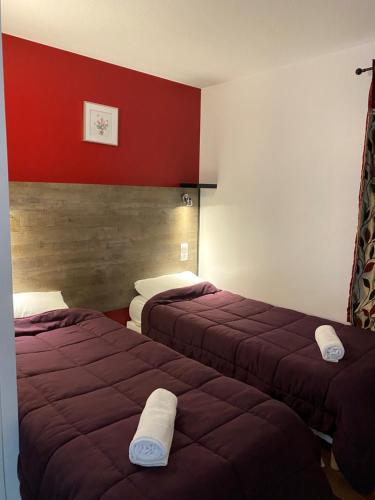 布里孔特罗贝尔Fast Hotel Brie-Comte-Robert的红色墙壁的酒店客房内的两张床