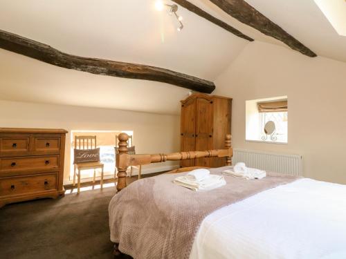 格洛索普The Cottage Glossop的一间卧室配有一张大床和一个木制梳妆台