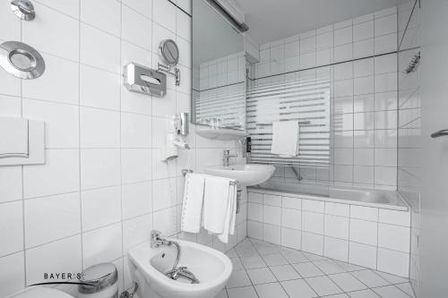 慕尼黑拜尔公寓式酒店的浴室配有盥洗盆、卫生间和浴缸。