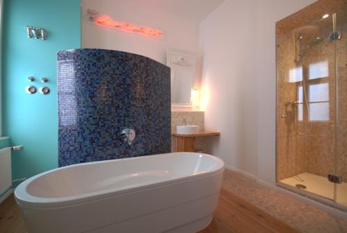 柏林阿特路易斯库申酒店的设有带浴缸和淋浴的浴室。