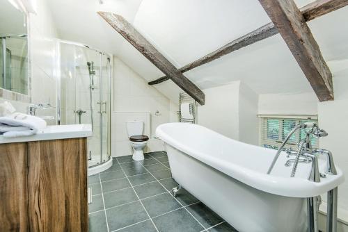 彭布罗克郡Clydey Cottages Pembrokeshire的一间带大浴缸和卫生间的浴室