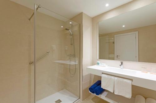 帕格拉HSM Solivera的带淋浴、盥洗盆和镜子的浴室