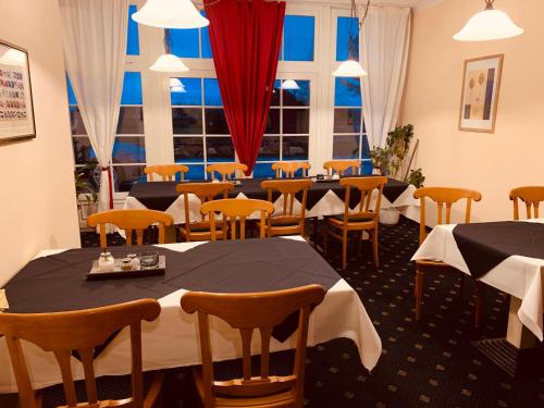 瓦尔内明德祖斯特兰酒店的餐厅设有桌椅和窗户。