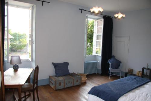 Les MarchesChâteau La Violette的卧室配有床、桌子和窗户。
