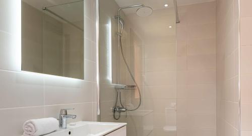 库克里亚4 bedroom Villa Helidoni with private infinity pool, Aphrodite Hills Resort的带淋浴、盥洗盆和镜子的浴室