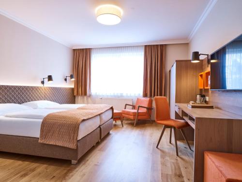 萨尔茨堡珀斯特绿色酒店 - 100％比奥的配有一张床和一张书桌的酒店客房