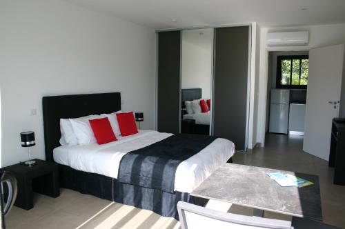 韦基奥圣露西港口Résidence Terre et Mer的一间卧室配有一张带红色枕头的大床