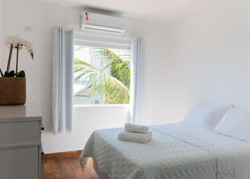 阿拉亚尔-杜卡布Casa Arraial do Cabo Beachfront的白色的卧室设有床和窗户