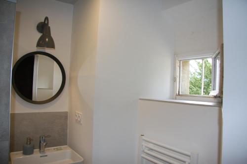 Les MarchesChâteau La Violette的一间带水槽和镜子的浴室以及窗户。