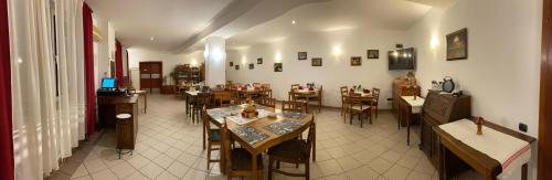 Sînnicolau MareVila Zoppas Inn的一间在房间内配有桌椅的餐厅