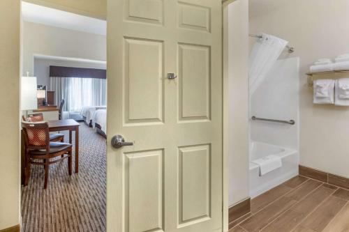 柯林斯堡Quality Inn & Suites University Fort Collins的通往带床和浴室的房间的门