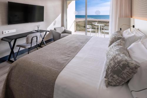 卡斯特尔德费尔斯贝莱尔酒店的一间卧室设有一张大床,享有海景
