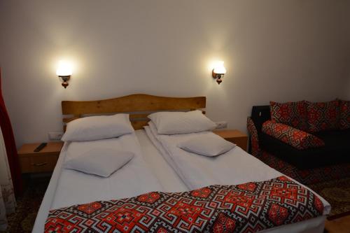瓦杜伊泽Casa Papițu的一间卧室配有一张大床和一张沙发