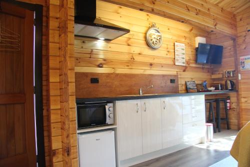特卡波湖Sunset Chalet的厨房配有白色橱柜和墙上的时钟