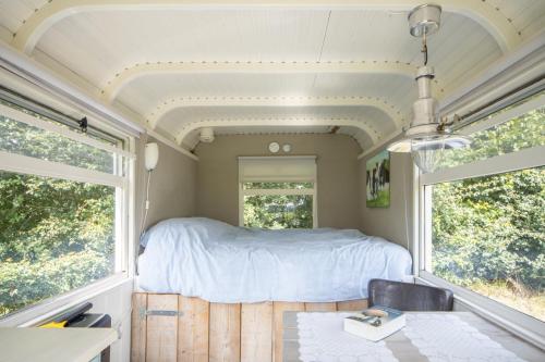 KuinrePipowagens 'Ot' en 'Sien'的拖车内的卧室,配有床和2扇窗户