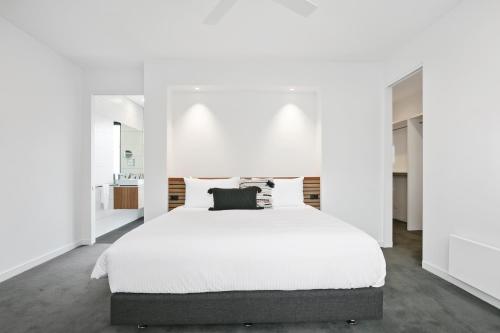 阿波罗湾Apollo Bay Beach House的白色卧室设有一张白色墙壁的大床