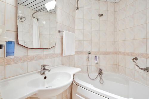 博德鲁姆Costa 3S Beach Hotel-All Inclusive的一间带水槽、浴缸和镜子的浴室