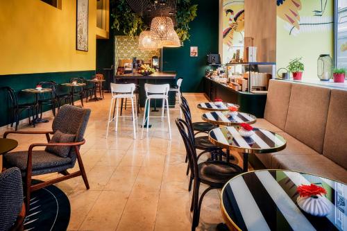 维也纳维也纳市阿德吉奥公寓式酒店的一间带桌椅的餐厅和一间酒吧