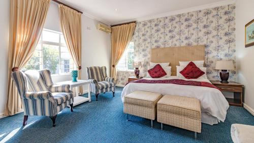 德班银橡树精品酒店的卧室配有一张床、一张桌子和椅子