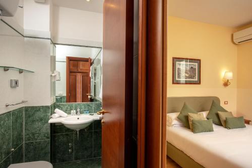 罗马圆形大剧场酒店的一间带床、水槽和淋浴的浴室