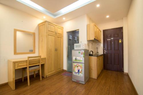 河内RedDoorz Newstyle Apartment Tran Duy Hung的一间带桌子和冰箱的小厨房