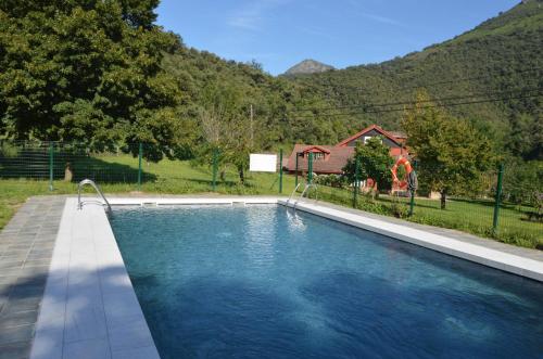 卡马莱尼奥极速酒店的一座带房子的庭院内的游泳池