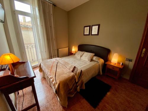 塞尔韦拉Hostal Bonavista的一间卧室配有一张带两盏灯的床和一扇窗户。
