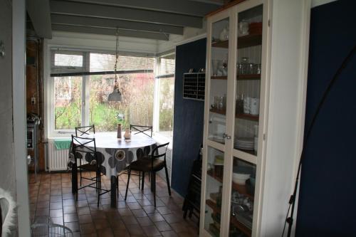 SchoorldamRekerlanden 80的一间带桌椅和窗户的用餐室
