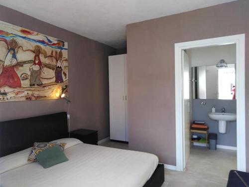 奥罗塞伊Casa Saba的卧室配有一张床,墙上挂有绘画作品