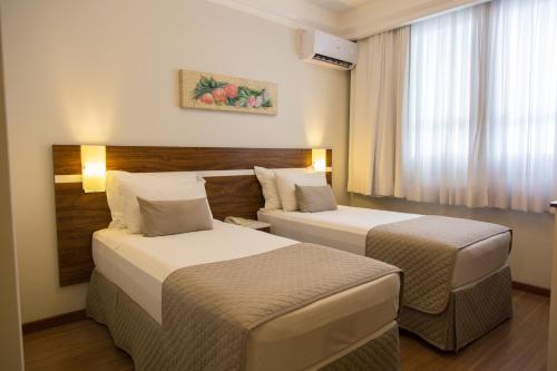 蓬塔格罗萨Hotel Princess的酒店客房设有两张床和窗户。
