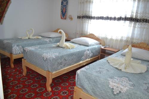 希瓦Khiva Karim Sulton的配有2张床的宿舍间,配有天鹅