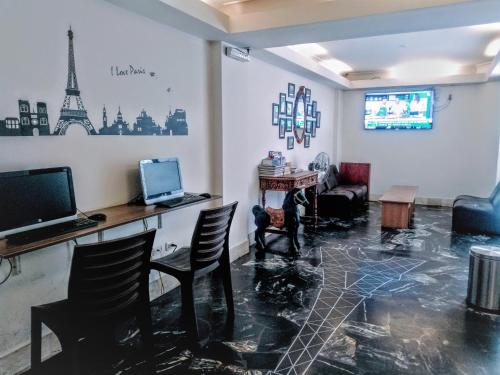 利马利马巴黎酒店的客厅配有桌椅和电视。