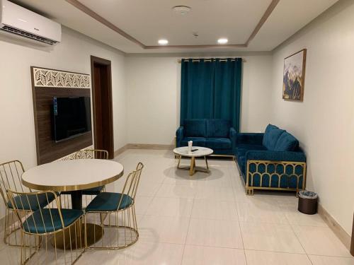 吉达Manazelna Aparthotel的客厅配有沙发和桌椅