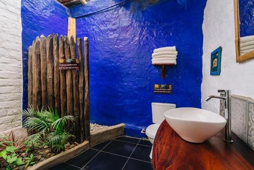 曼克拉马库拉琪姆巴斯简易别墅的蓝色的浴室设有白色卫生间和蓝色的墙壁