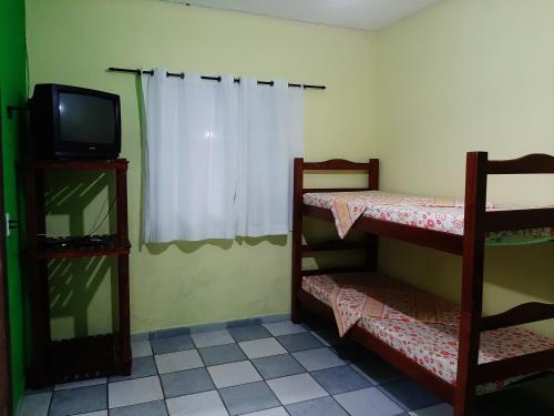 乌巴图巴Pisco Chalés的配有电视和两张双层床的客房