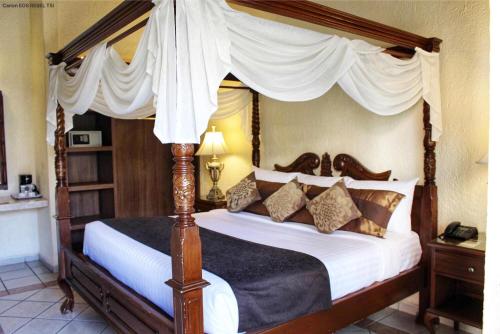瓜达拉哈拉波萨达韦睿酒店的卧室配有带枕头的天蓬床