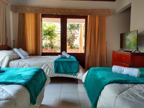 莱瓦镇Hospedaje Casa Marsella的酒店客房设有两张床和窗户。