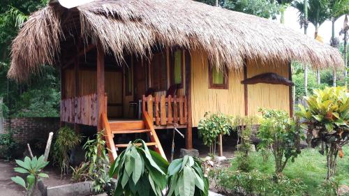 HitokalakLena house Flores的茅草屋顶和门廊的小小屋