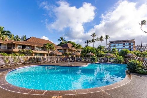 拉海纳雅诗顿毛伊卡阿纳帕利别墅酒店的度假村的游泳池,配有椅子和遮阳伞