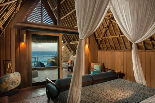 Tanjung Ringgit捷瓦贝罗亚马海滩营地酒店的一间卧室配有一张床,享有海景