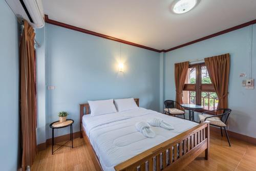 清刊Primmalyn บ้านพริมมาลีณ的一间卧室配有一张带白色床单的大床