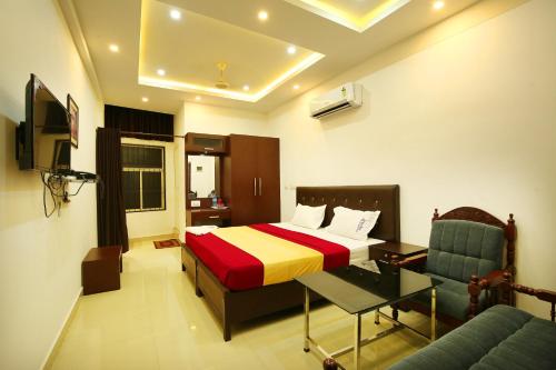 马拉普兰karibu Residency的一间卧室配有一张床、一张桌子和一张沙发