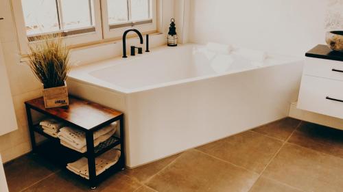 比苏姆Hotel garni Seeluft Büsum的厨房里设有一个大型白色浴缸,配有水槽