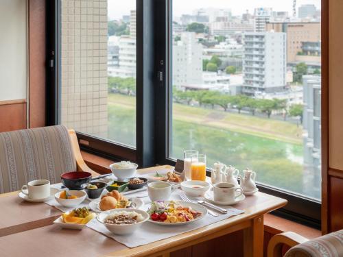 水户水戶总统大酒店(President Hotel Mito)的桌子上摆着一桌带早餐食品的桌子,窗户