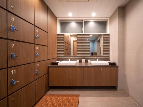 丸龟市Super Hotel Marugame Ekimae的一间带两个盥洗盆和大镜子的浴室