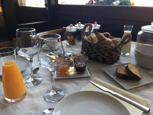 ArandasAuberge à la Vieille Cure的一张桌子,上面放着一盘面包和一杯橙汁