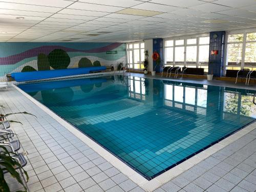 库罗阿尔滕堡卢格斯滕霍夫酒店的大楼内一个蓝色瓷砖的大型游泳池